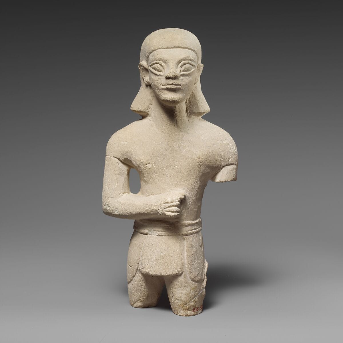 Limestone statuette of a beardless male votary in Egyptianizing dress - image 1