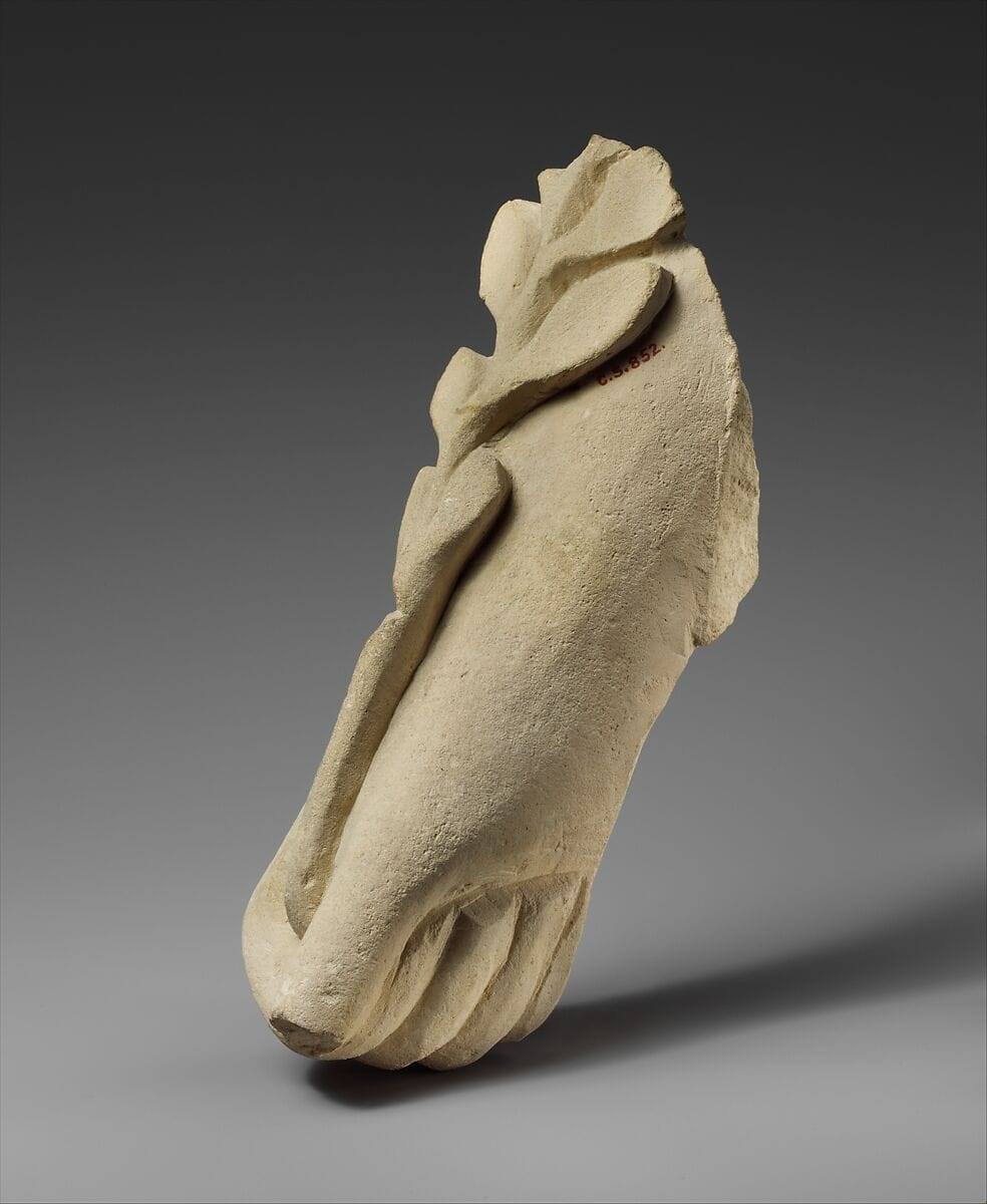 Limestone hand holding a branch of leaves - image 1
