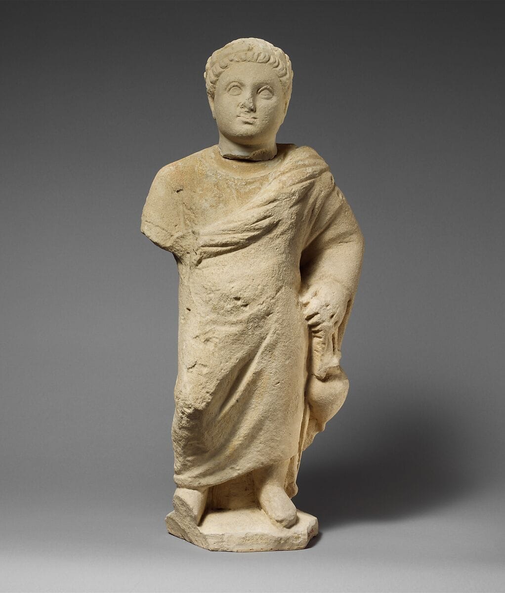 Limestone statuette of a boy holding an amphora - image 1