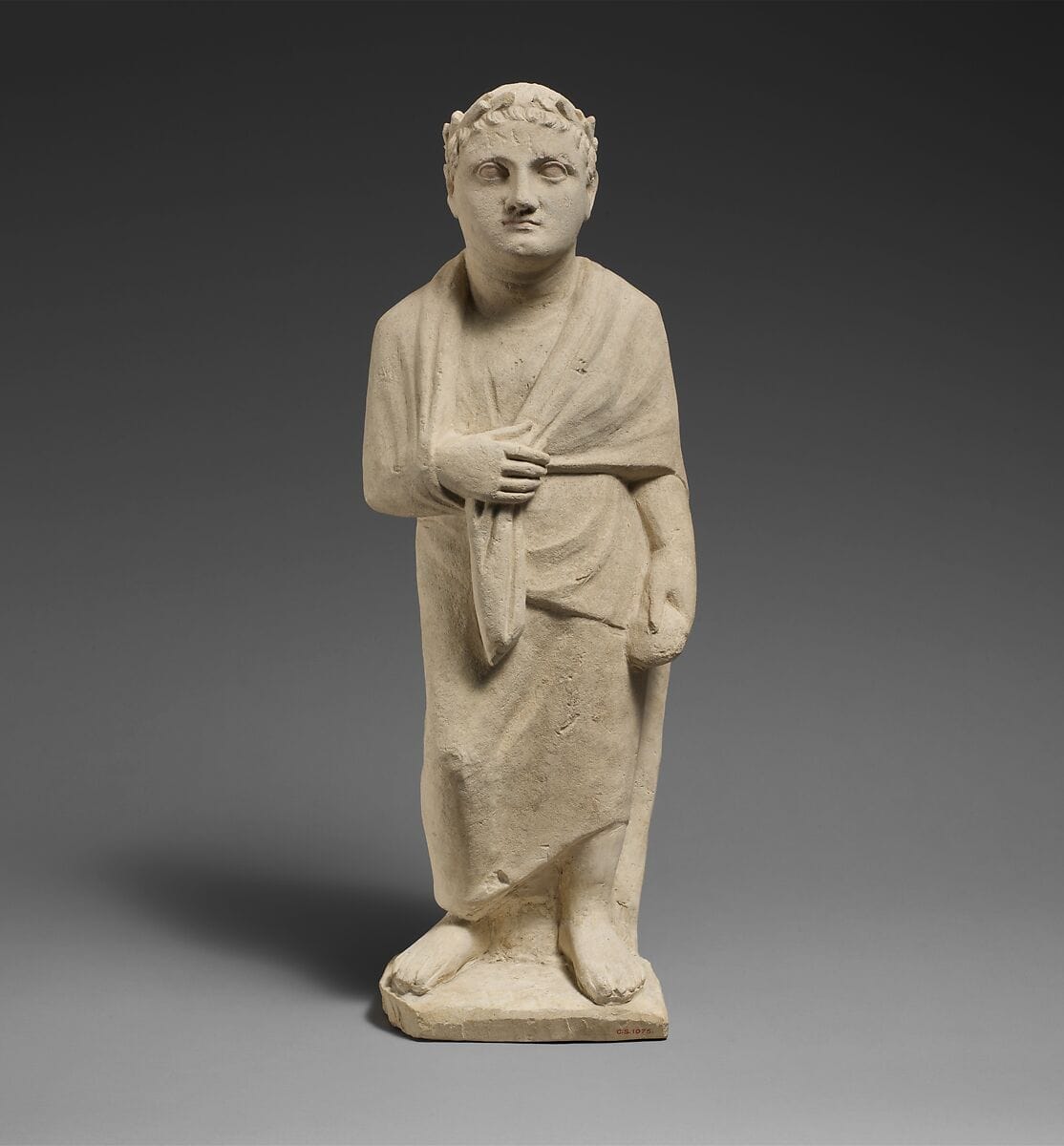 Limestone statuette of a boy holding a pyxis - image 1