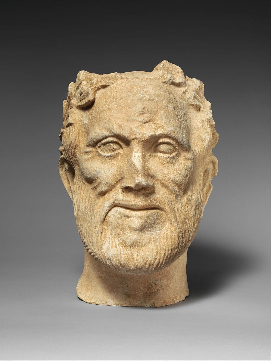 Limestone head of bearded male votary with wreath of leaves - image 1