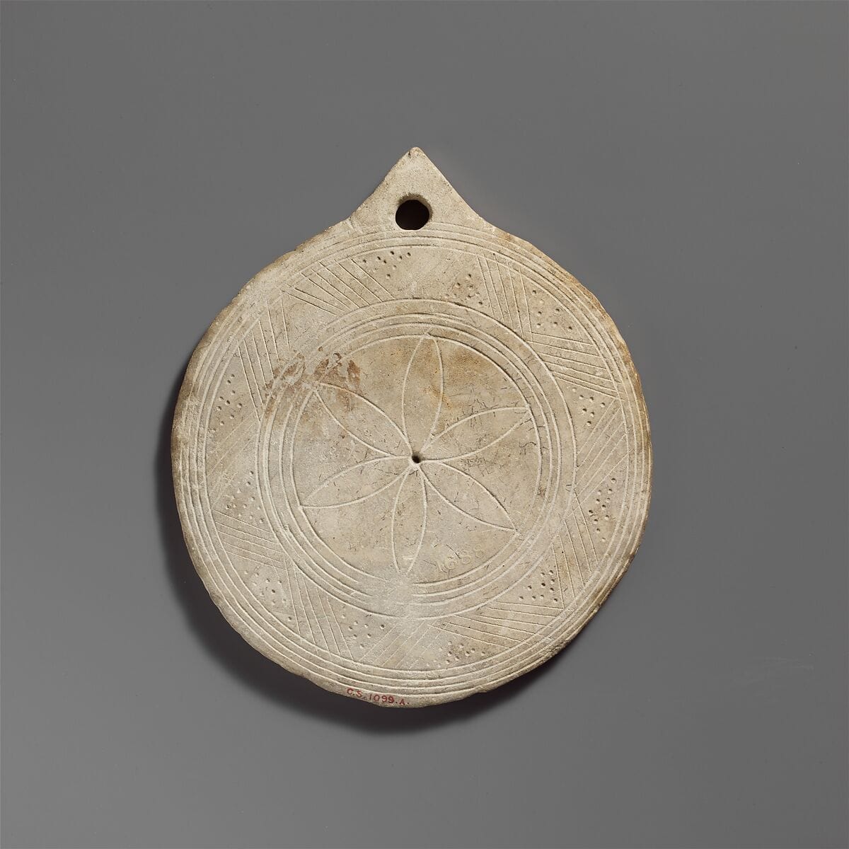 Limestone disk with geometric decoration - image 1